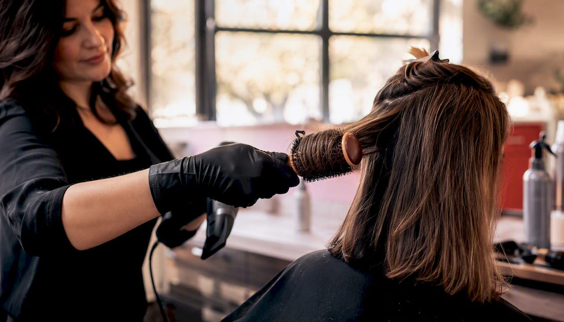 Stylist styling hair with round brush