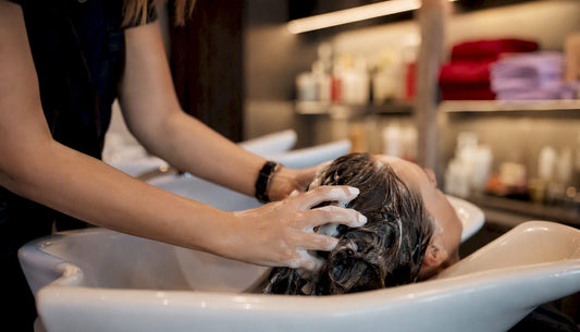 Stylist washing hair with clarifying shampoo