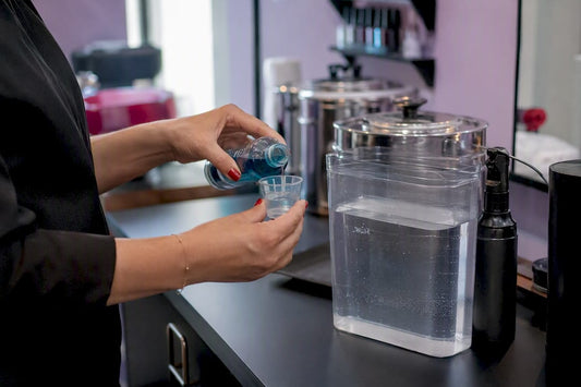 Hands mixing Barbicide concentrate with water