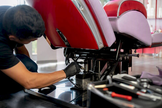 Technician servicing salon chair hydraulic pump